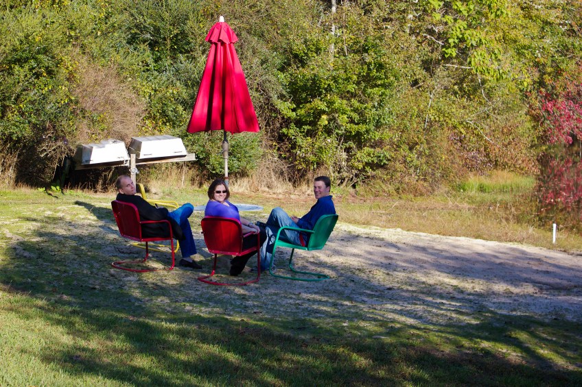 Three People Sitting in Chairs on the Beach